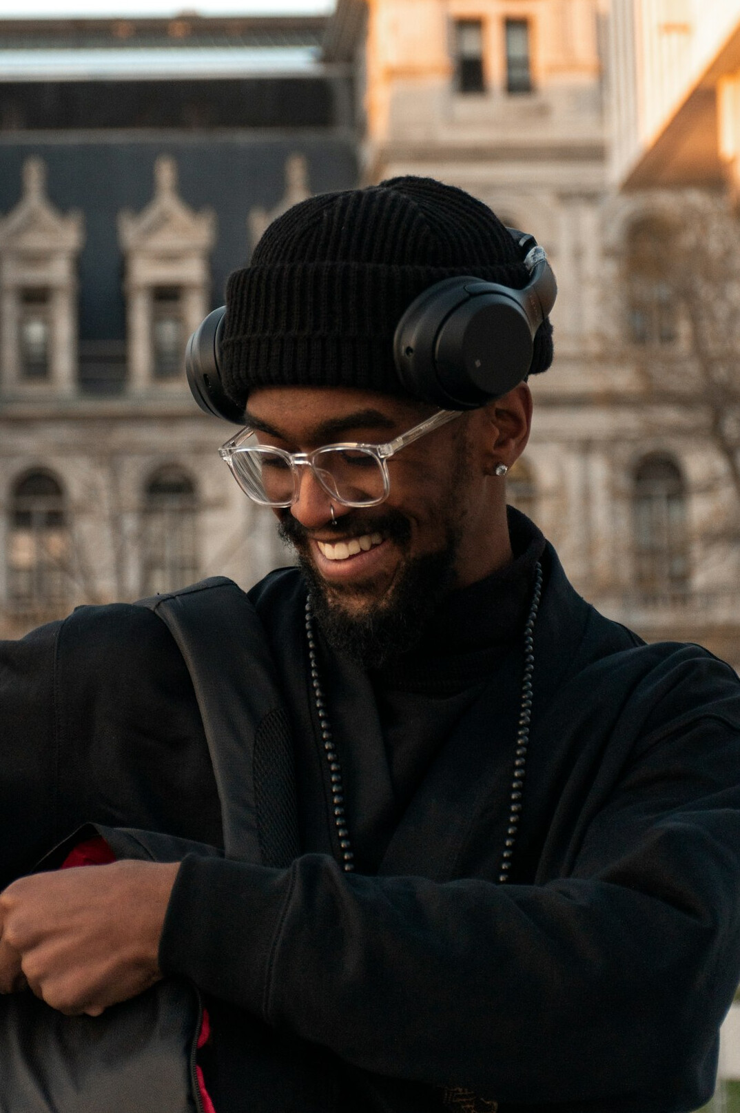 Bearded man with glasses and headphones at an editing desk