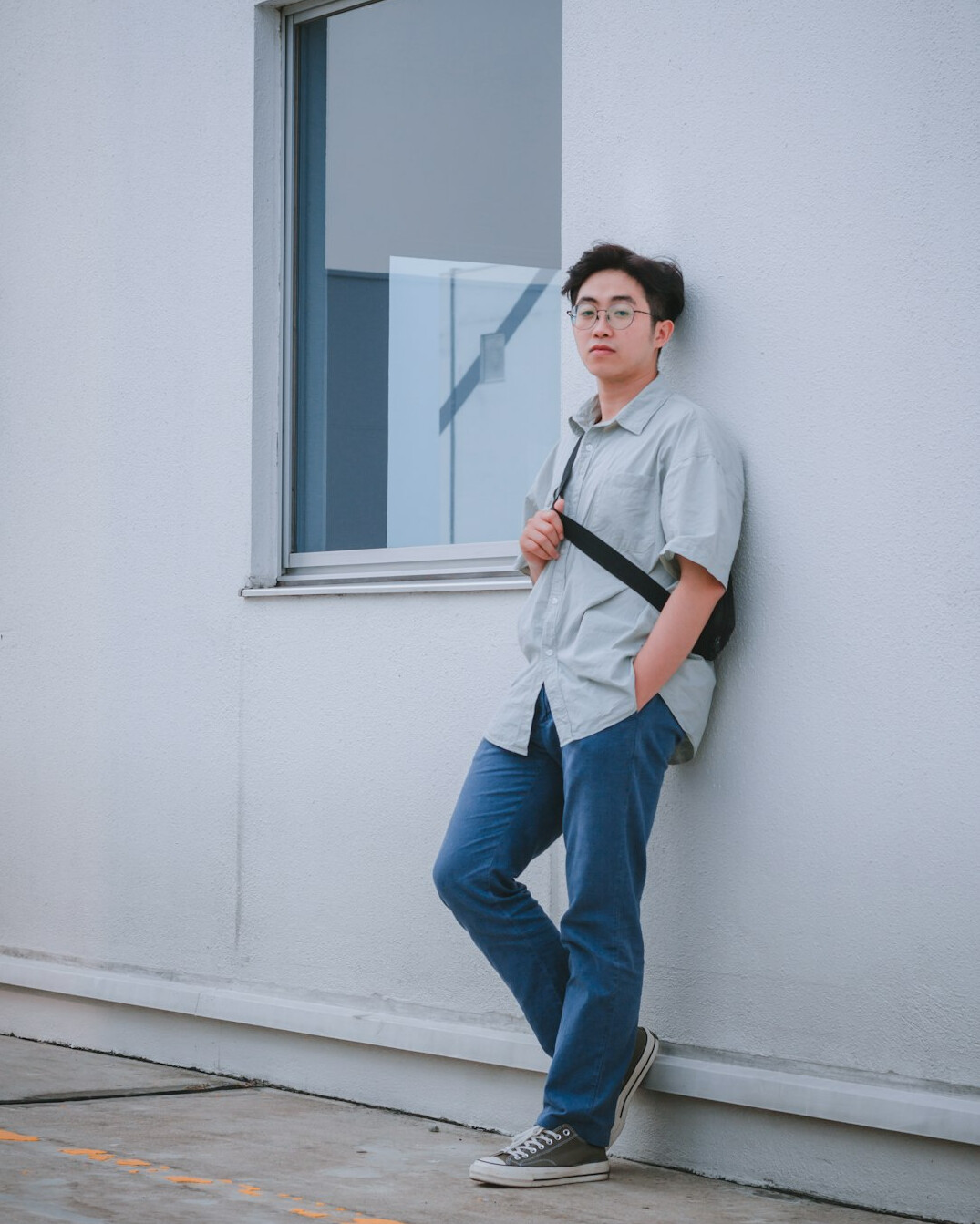 Portrait of a young man student with a camera strap