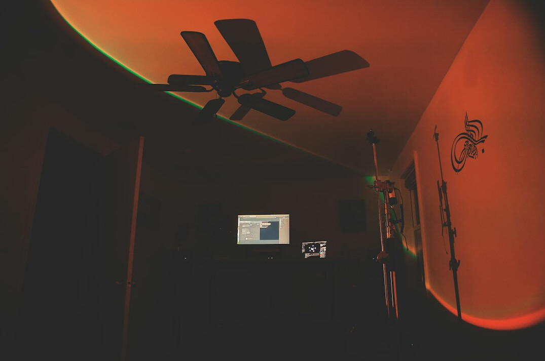 Video editing workstation with timeline on a large monitor in a dim studio